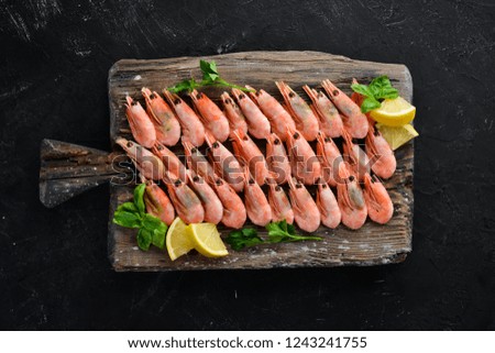 Shrimp on a wooden board. Seafood. On the old background. Top view. Free copy space.