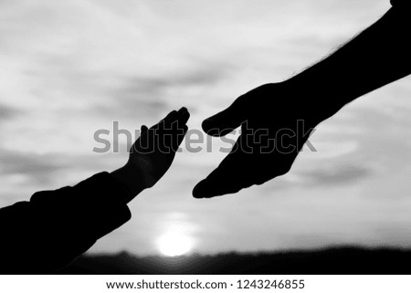 silhouette the parent holds the hand of a small child