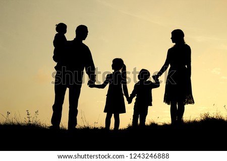 silhouette of a happy family with children on nature

