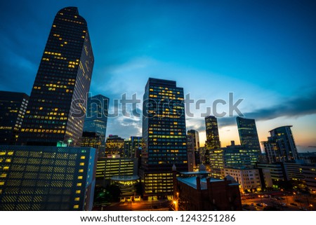 Blue Hour Sunset in Denver , Colorado , USA at Dusk in Downtown City glowing Nightscape Skyline of the Mile High City Skyscrapers and office buildings rising up into the night sky 