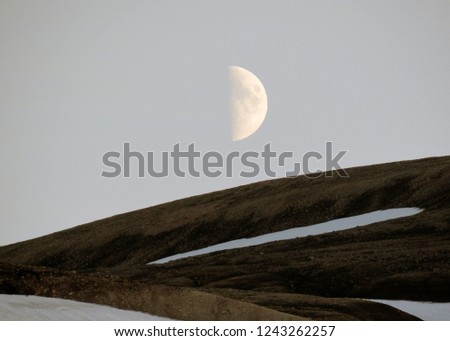 Beautiful landscape of Landmannalaugar with snow and waxing moon, on the top of the mountain Blahnukur during the sunset, summer, Iceland