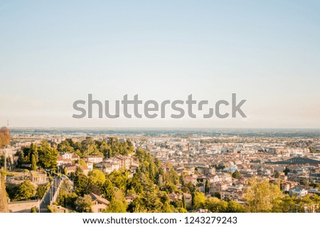 Sunset on the background of the lower town of Bergamo. View from the upper city of Bergamo, Italy. Residential buildings.