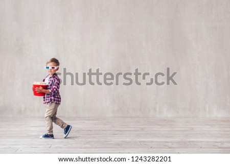 Little child in 3d glasses with popcorn