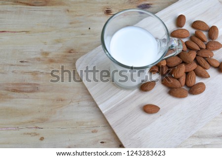 Almonds, almonds, almonds, wooden table alms, almond milk, almonds in a glass bowl.