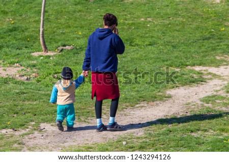 Woman with child go hand in asian village .