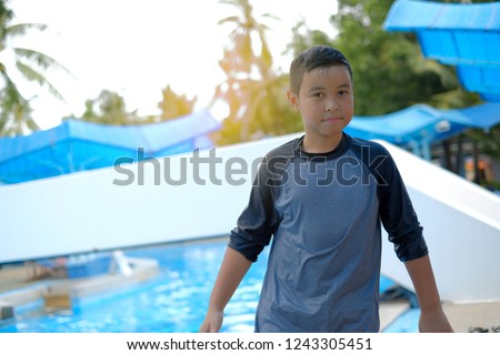 Asian children in swimming suit smiling confident and happy in water park.