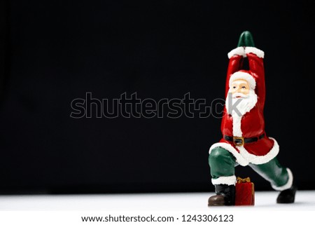 Santa Claus ready for give gift for Christmas eve and poses like a yoga practice be easily changed into overlay isolated on black background with copy space