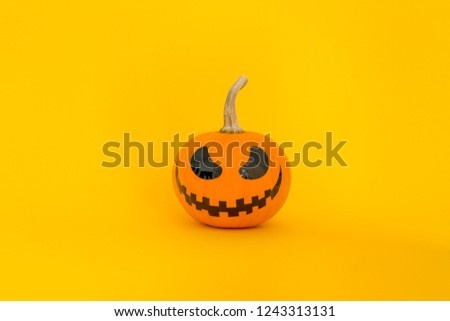 orange pumpkin with eyes on a yellow background.