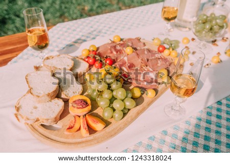 Light summer picnic in the park on a wooden table. Against the background of a green lawn in sunny weather.