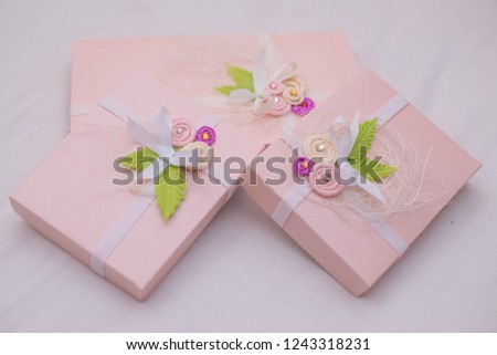 three delicate pink boxes with floral decorations and rhinestones