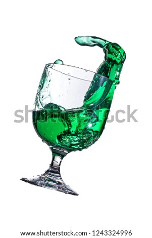green juice splashing in a glass on a white background