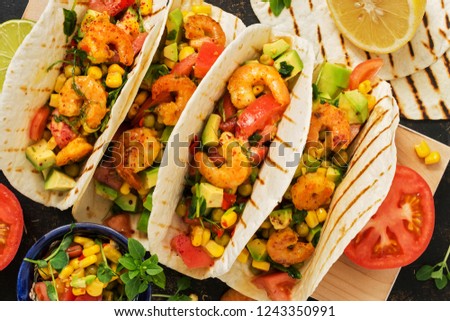 Tacos with shrimps and vegetables close-up. Traditional Mexican food. Top view