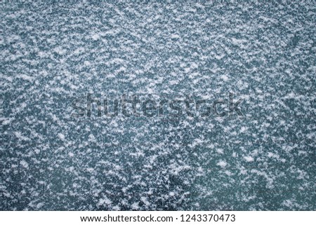 the texture of white fine snow on the glass. Background for cold winter