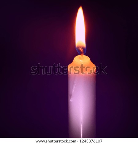 a burning candle in the dark