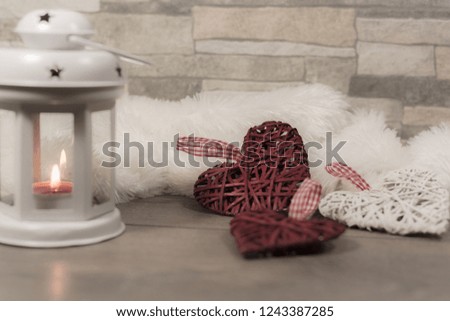 Winter composition with cozy pillow, lantern and heart ornaments. Winter holidays concept.