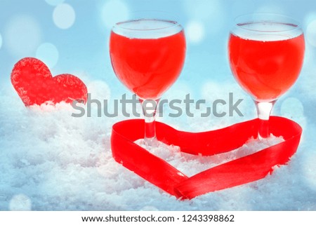 Champagne glasses, present and roses in front of winter background