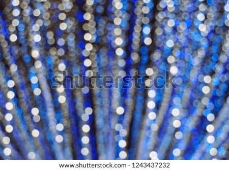 defocused blue and white small christmas lights bokeh, blurred decorative hanging lights for christmas festive night party, abstract pattern background