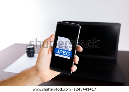 Holding a smartphone on hand with a JPEG sign logo