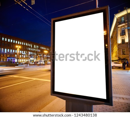 Billboard Outdoor Advertising on the street glows at night. Layout for advertising design. Lightposter pylon with a white field.