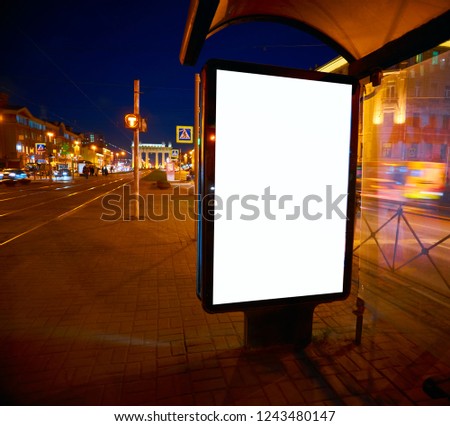Billboard on the street glows at night. Layout for advertising design. Sheet pylon with a white field in stopping pavilion bus shelter Outdoor Advertising