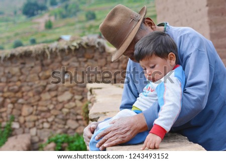 Native american grandfather hugging his grandchild outside. 