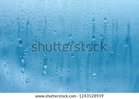 The texture of natural water drops on glass. High humidity indoor. Close-up with condensation