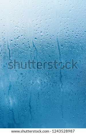 Window glass with high humidity condensation. Natural water background. Vertical photo. Copy space