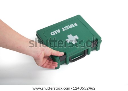 Male hand opening and holding a green plastic first aid box on a white studio background. Concept, health, medical and accident. UK