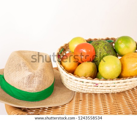 Basket of fruit and straw hat on the table. Agriculture concept 