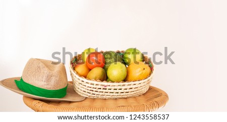 Basket of fruit and straw hat on the table. Agriculture concept 