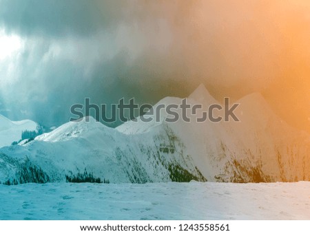 Winter mountain view in Carpathian mountains with dramatic clouds.
