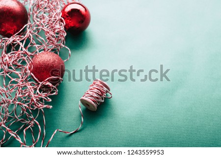 Christmas balls on green paper background, thread for gift wrapping, copy space