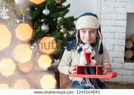 New Year's photo of a boy in a hat with a toy in his hands and a smile on his face