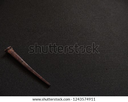 Rusty handmade square cut nails on charcoal grey background 
