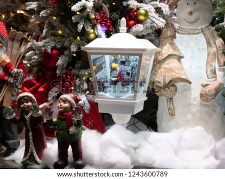 showcase of toy store decorated for Christmas by magic lantern, snowman and pair of forest elfs