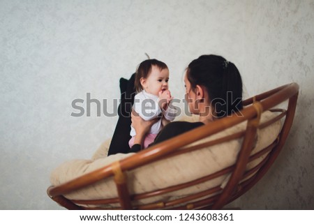 Funny baby girl with mother at home.
