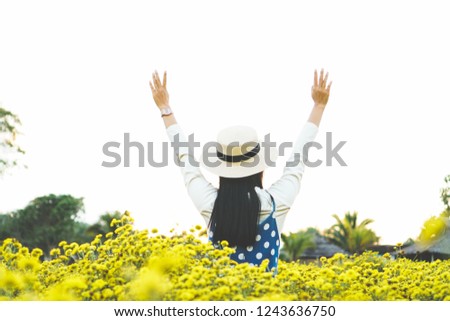 Young woman is standing on a flower field.