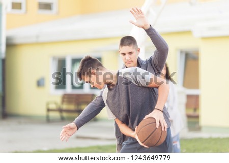Young adults playing basketball