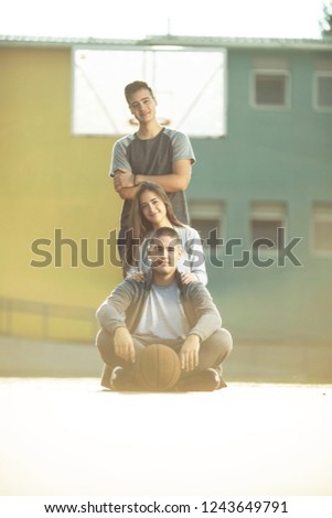 Three friends sitting on the basketball court