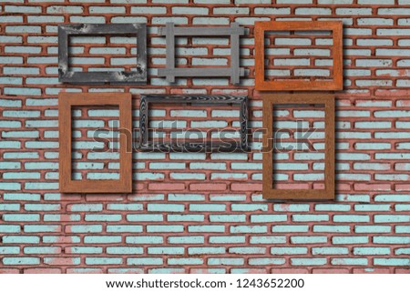 Old photo frames on bricks wall. Wooden picture frame.