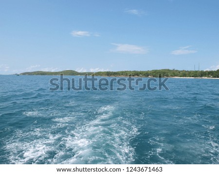 Sea waves or bubbling waves on the sea from the tail boat. It is a sign of the movement of the boat in the water. The island is blue and the sky is blue.
