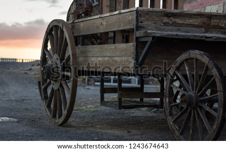 Wooden coach with sunset sky on background. Rusty old western carriage, vintage transportation concept