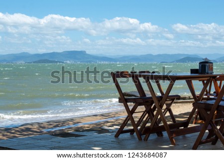 Photographic camera on wooden table at the seaside.