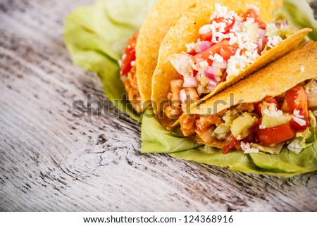 Chicken tacos with lettuce, tomato and sauce