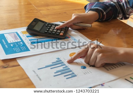 Woman working with calculator for calculating numbers.Expenses calculator,Loan investment documents.