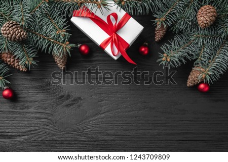 Christmas card with white gifts and fir branches on a dark wooden rustic background, place for text. Xmas and happy new year greeting card. Top view, flat lay. 