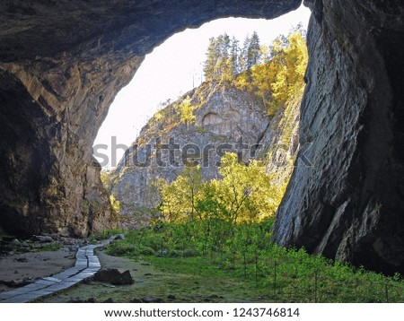 View from inside the cave. Stone arch in the mountains