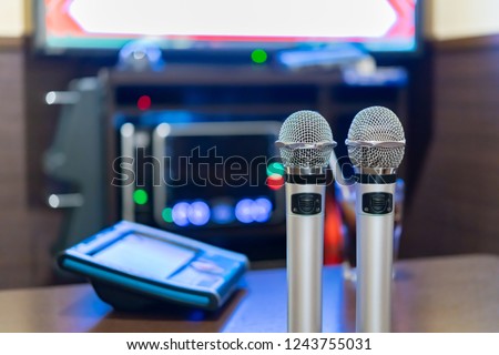 Microphone and remote control in karaoke box Royalty-Free Stock Photo #1243755031