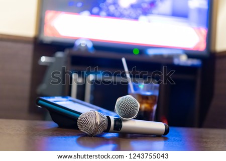 Microphone and remote control in karaoke box Royalty-Free Stock Photo #1243755043