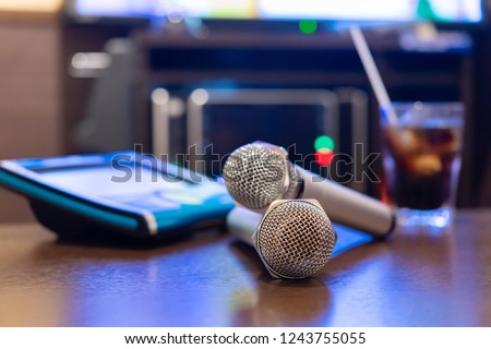 Microphone and remote control in karaoke box Royalty-Free Stock Photo #1243755055